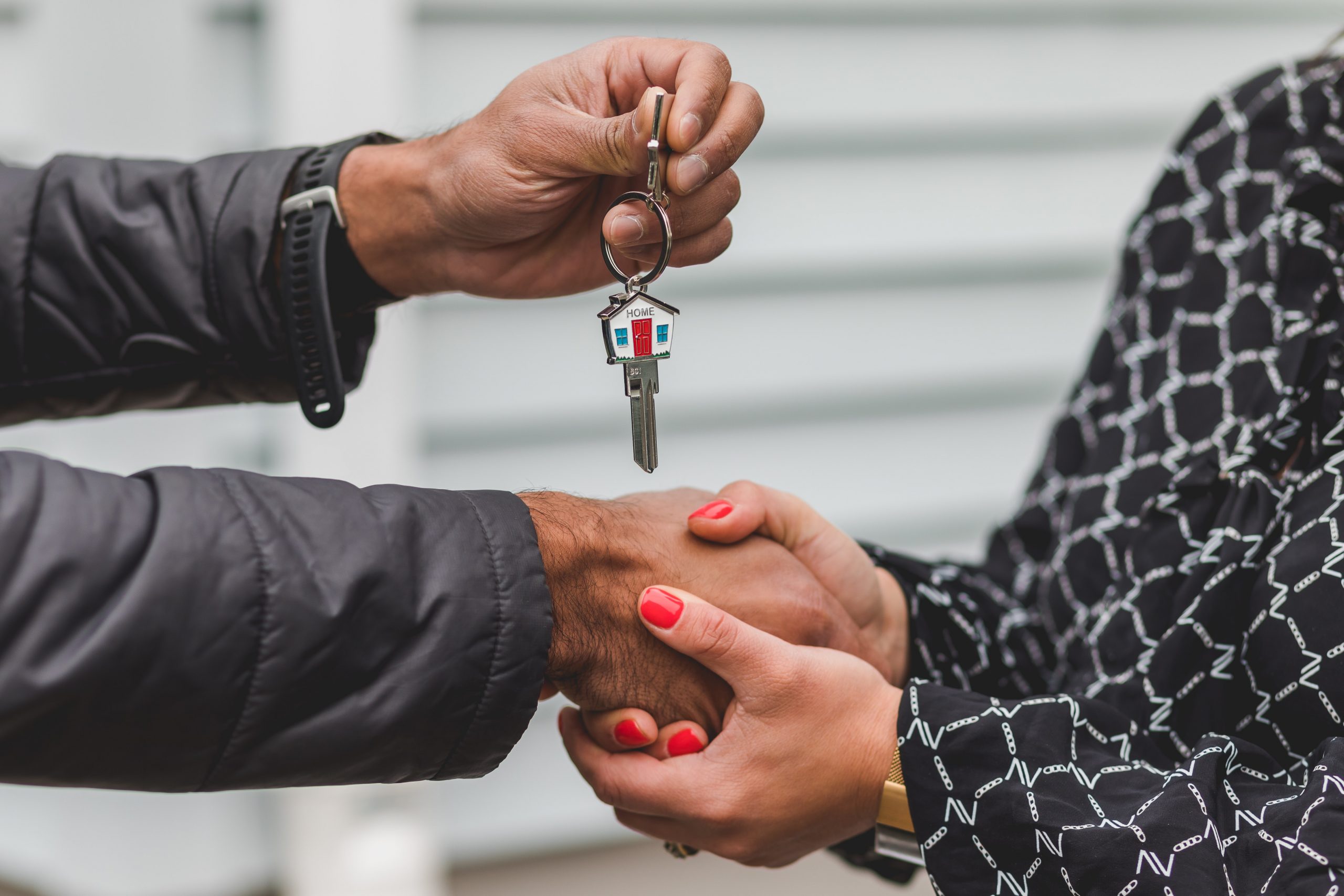 woman and man shaking hands and man passing woman key